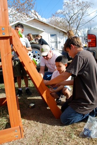 Youth and adults from WordServe build a swingset for a local resident during a Youth-led Compassion Project.